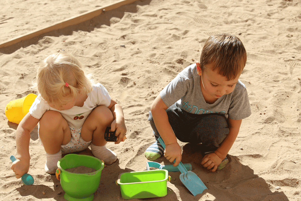 niños jugando en arena en el patio