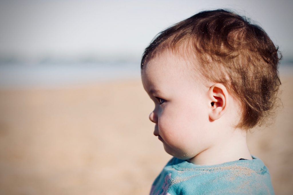 niña de uno 10 meses de perfil mirando al horizonte
